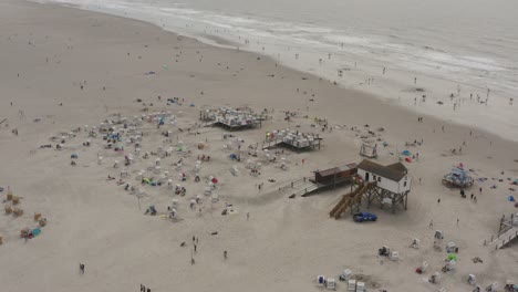 Drone---Aerial-shot-of-the-sandy-beach-with-tourists-and-people-in-St