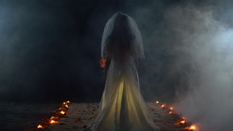 A-ghost-bride-surrounded-by-candles-standing-in-a-dark-scary-room