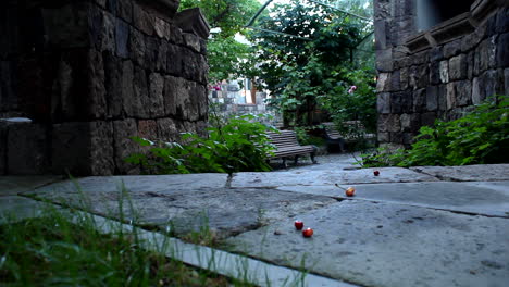 A-Beautiful,-Quiet-Park-With-Benches-By-Stone-Walls-And-Plants-On-A-Windy-Day---Wide-Pan-Shot