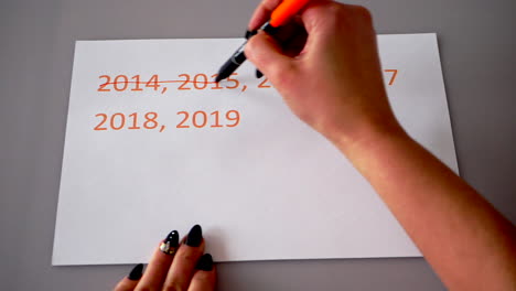 Crossing-out-the-last-year's-dates-on-a-white-paper,-then-writing-the-correct-recent-or-new-year-2020