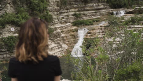 Woman-standing-by-waterfall-in-Nature-Reserve-Cavagrande-in-Sicily