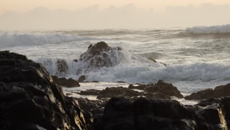 Meereswellen,-Die-Langsam-In-Große-Felsformationen-An-Der-Küste-Einschlagen