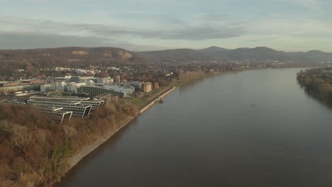 Cinematic-drone---aerial-shot-of-the-river-rhine-with-the-Siebengebirge-seven-mountains-and-the-Kameha-Grand-Hotel-Bonn-Königswinter-at-golden-hour-afternoon,-24p