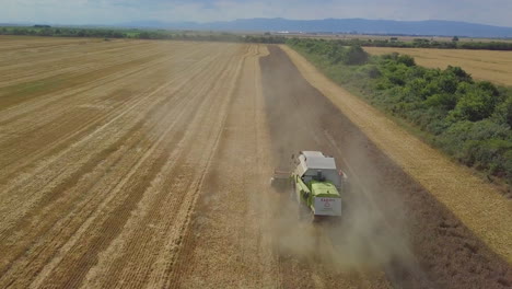 Drone-shot-over-reaping-harvester-in-agriculture-field