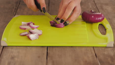 Women-dicing-red-onions-on-chopping-board-in-kitchen