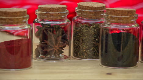 Selection-of-Jars-with-dried-spices-laid-out-in-a-row-on-wooden-table