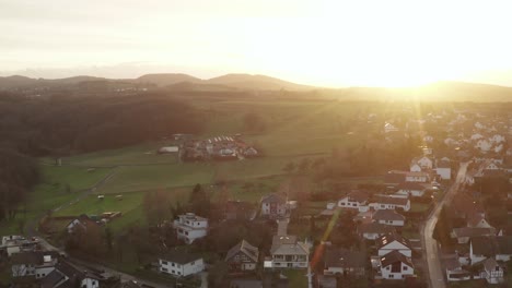Drone---Aerial-fly-away-shot-of-a-sunset-of-a-little-village-at-a-beautiful,-vibrant-color-sunset,-Oelberg,-Siebengebirge,-Bonn,-Königswinter-24p