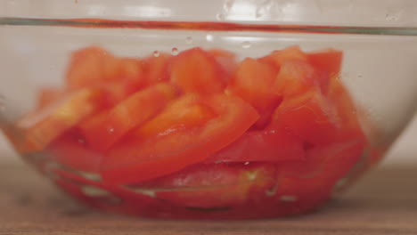 Fresh-sliced-tomatoes-pieces-being-dropped-into-bowl