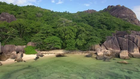Drohnen-Tracking-Aufnahme-Des-Wunderschönen-Tropischen-Strandes-In-La-Digue,-Seychellen,-Unter-Blauem-Himmel-Mit-Türkisfarbenem-Wasser
