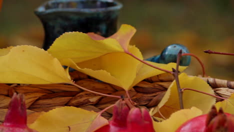 Weidenkorb-Mit-Roten-Reifen-Granatäpfeln-Und-Gelben-Herbstblättern