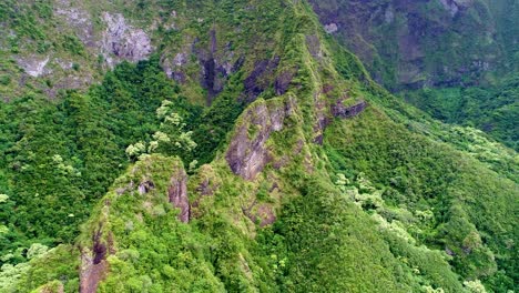 Side-pan-aerial-into-cave-entrance,-rainforest-on-Hawaii