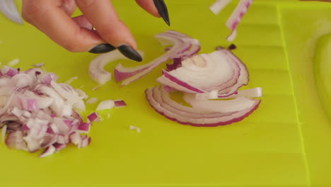 Women-separating-rings-from-red-onion-on-chopping-board