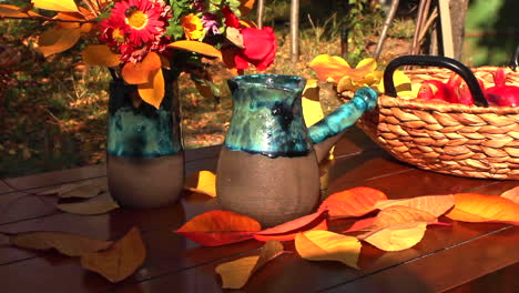 Thanksgiving-Tisch-Mit-Weidenkorb-Voller-Walnüsse,-Rote-Granatäpfel-Und-Frische-Blumen