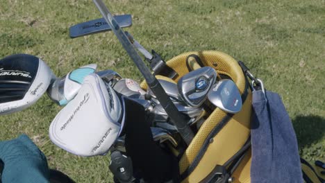 Overhead-close-up-shot,-high-def,-hand-selecting-golf-club,-pulling-out-of-golf-bag