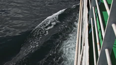 Side-Of-Ferry-Boat-Travelling-On-The-Blue-Ocean-Leaving-A-Wake-And-Waves-ON-The-Surface