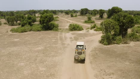 African-safari-jeep-driving-through-dusty-plains-as-seen-from-above