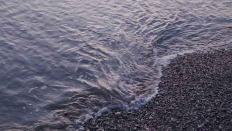 Close-up-overhead-shot,-foamy-waves-splashing-pebbles,-peaceful-nature-background