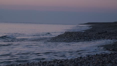 Focused-shoreline-waves-crashing-rocky-beach,-sunrise,-Mojacar,-Almeria,-Spain