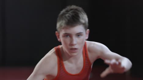 Teenage-wrestler-wearing-a-red-singlet-and-practice-his-shadow-wrestling-drills