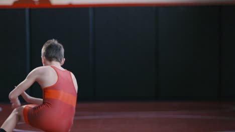 Teenage-wrestler-working-on-his-stance-and-motion-drills-during-practice