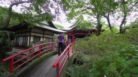 Ein-Vater-überquert-Mit-Seinem-Sohn-Die-Brücke-In-Einem-Shinto-Tempel