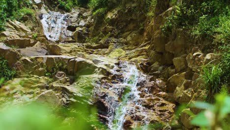 Water-cascades-down-rocky-waterfall-in-Rwanda-Volcanoes-National-Park