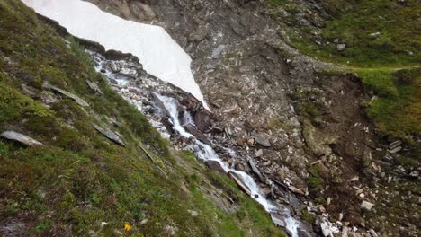 Static-view-of-fast-flowing-alpine-waterfall-in-rough-and-steep-mountain-terrain