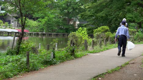 In-the-summer-of-Zempukuji-Park,-in-Tokyo,-Japan,-many-people-go-for-walks-along-its-different-trails,-refreshing-themselves-by-the-shade-of-the-trees,-its-lakes-and-the-deep-green-of-nature