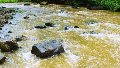 Un-Gran-Río-Que-Fluye-Rápidamente-Cae-Sobre-Enormes-Rocas-A-Través-De-La-Selva-Tropical-En-África