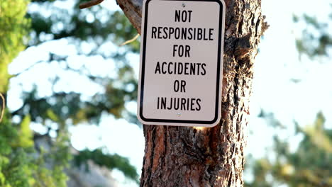 Warning-Signage-On-A-Tree-Trunk-At-Summer-Daytime