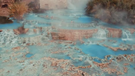Tourists-At-The-Cascate-del-Mulino-In-Saturnia,-Manciano-In-Italy---Steam-Rising-Up-From-The-Thermal-Baths