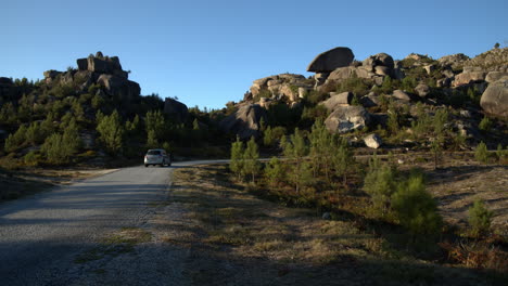 Car-driving-and-taking-a-curve-in-a-rocky-mountain-of-Geres,-Portugal
