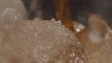 Side-close-up-of-cola-being-poured-into-glass-with-ice