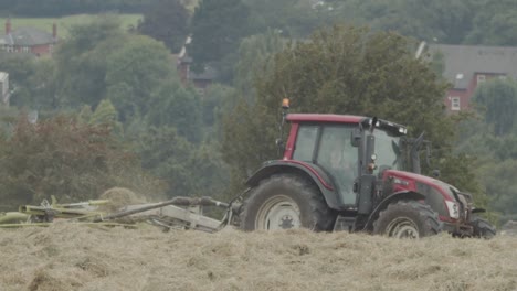A-tractor-moves-across-a-field-harvesting-a-crop