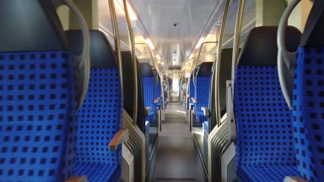 Caminando-A-Través-De-Un-Tren-Alemán-Vacío-En-Movimiento-Con-Asientos-Azules
