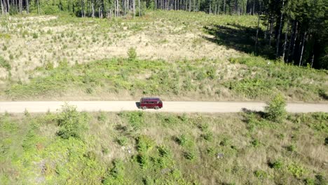 VW-Van-vintage-van-driving-through-forest-aerial-view-4k-drone