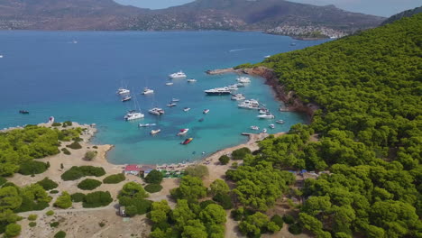 Ascending-drone-shot-of-moored-yachts-and-catamarans-on-a-beautiful-bay-for-diving
