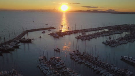 Beautiful-sunset-drone-shot-of-yacht-harbor-and-sun-reflection-in-the-water