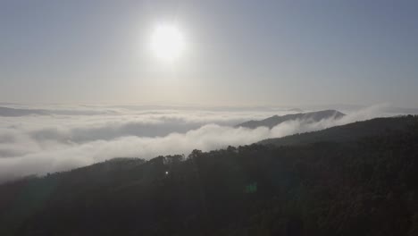 Ascending-drone-shot-over-mountains-in-portugal-covered-with-low-clouds-on-a-foggy-day