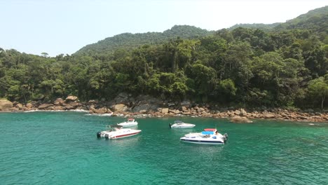 Tropical-island-with-forest---boats-on-secluded-anchor-sea-in-Isla-Grande-Brazil