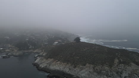 AERIAL---Foggy-Punta-Zapallar-in-Zapallar,-Valparaiso,-Chile,-wide-spinning-shot