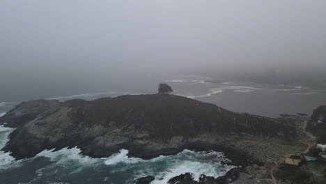 AERIAL---Foggy-Cerro-de-la-Cruz,-Zapallar,-Valparaiso,-Chile,-wide-circle-pan