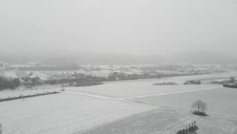 Verschneite-Landschaft-In-Der-Nähe-Des-Ländlichen-Dorfes-Bei-Schneefall-Im-Winter