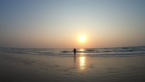 Ein-Asiatischer-Indischer-Mann,-Der-Während-Der-Sommerferien-An-Einem-Wunderschönen-Strand-In-Den-Sonnenuntergang-Läuft