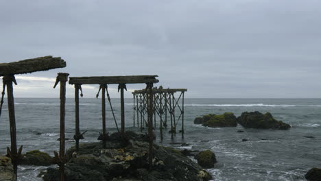 Ruins-of-the-historic,-120-year-old-dock-in-Llico,-Vichuquen,-Chile,-wide-shot