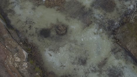 Aerial-view-drone-flight-pan-down-over-lake-in-Kinnekulle-Sweden