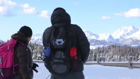 Dos-Excursionistas-Mirando-Y-Señalando-Montañas-Nevadas-En-Invierno-En-Un-Día-Soleado