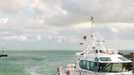 Rotes-Und-Weißes-Lotsenboot-Segelt-Vom-Offenen-Blauen-Meer-Mit-Wolken-Und-Blauem-Himmel-In-Den-Hafen-Von-Seeland-In-Den-Niederlanden