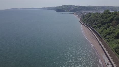 Teignmouth-rail-line-along-coast-with-train-coming-towards-the-camera