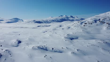 Beautiful-cinematic-aerial-shot-flying-over-an-untouched-snow-covered-landscape